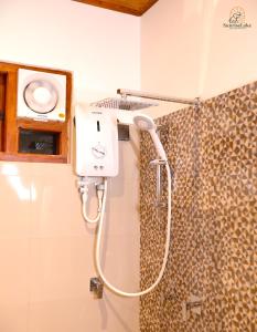 a shower in a bathroom with a hair dryer at Sunrise Lake Resort in Polonnaruwa
