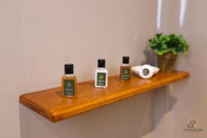 a bathroom shelf with three bottles of soap on it at Sunrise Lake Resort in Polonnaruwa