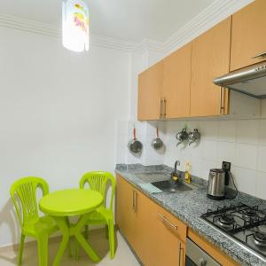 马拉喀什NS 53 by KMREI Properties的厨房配有绿色的桌椅