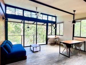 a living room with a blue couch and a table at Oleadas Maderas in San Juan del Sur +78 photos