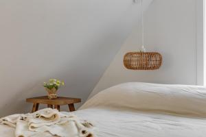 a bedroom with a white bed and a table with flowers at Cabin N2 Le Signal Forest View and Jacuzzi in Saint-Aimé-Du-Lac-des-Îles