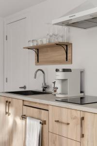 a kitchen with wooden cabinets and a sink at Cabin N2 Le Signal Forest View and Jacuzzi in Saint-Aimé-Du-Lac-des-Îles