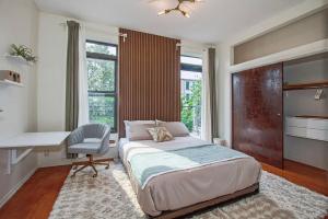 a bedroom with a bed and a desk and a chair at Private Double Queen Suite in Brooklyn Brownstone in Brooklyn