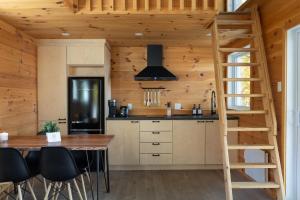 a kitchen with a staircase in a log cabin at Cabin N1 Les Grand'Pares Lake view Jacuzzi in Saint-Aimé-Du-Lac-des-Îles