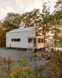 a tiny house in the middle of a field at Cabin N1 Les Grand'Pares Lake view Jacuzzi in Saint-Aimé-Du-Lac-des-Îles