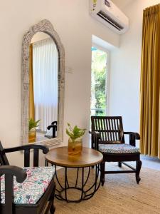 a living room with two chairs and a table and a mirror at Beijo do Sol, Goa Private Pool Luxury Villa in Jāmb