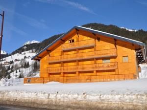 a large wooden building with snow in front of it at Charmant studio avec terrasse exposée sud et accès Multi Pass à 3€/jour/personne ! - FR-1-692-72 in La Chapelle-dʼAbondance