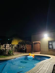 a swimming pool at night with a light in the background at LINGAS inn in Richards Bay