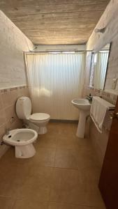 a bathroom with two toilets and a sink at Los Horneros Aparts - La Aguada in La Paloma