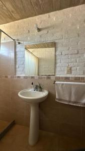 a bathroom with a sink and a mirror at Los Horneros Aparts - La Aguada in La Paloma