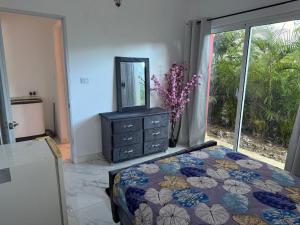 a bedroom with a bed and a dresser with a mirror at Your best vacation stay in Boca Chica +6 photos