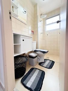a bathroom with a toilet and two mats on the floor at Apto Centro cambui em Campinas in Campinas +9 photos