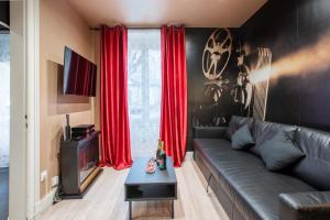 a living room with a couch and red curtains at Hollywood Night-Jacuzzi & Private Movie Theater in Mulhouse
