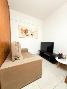 a living room with a couch and a flat screen tv at Apto Centro cambui em Campinas in Campinas