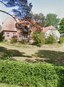 una antigua casa de ladrillo rojo con un gran patio en Pine Haven, en Odense