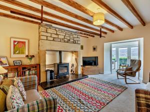 a living room with a fireplace and a couch at 3 Bed in Alnwick 93171 in Edlingham