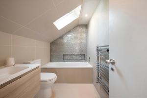 Un baño con bañera, inodoro y lavabo. en Cece, en Londres