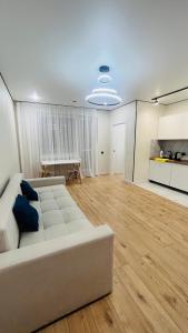 a living room with a white couch and a table at 2-комнатная новая квартира возле Хан-Шатыра in Astana