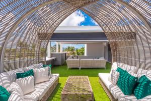 Una zona de estar al aire libre con una pérgola de mimbre en Villa Seminole, en Fort Lauderdale