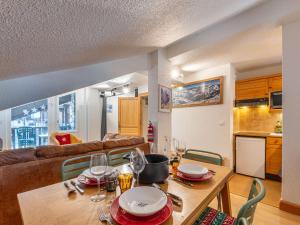 - un salon doté d'une table avec des assiettes et des verres à vin dans l'établissement Duplex 3 pièces avec wifi et parking, 6 pers., au pied des pistes à Val-d'Isère - FR-1-694-422, à Val dʼIsère