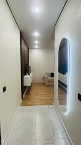 a white room with a bed and a mirror at 2-комнатная новая квартира возле Хан-Шатыра in Astana