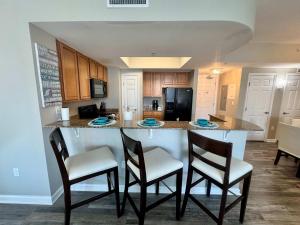 cocina con barra con 4 sillas y barra en A Wave From it All, en Destin