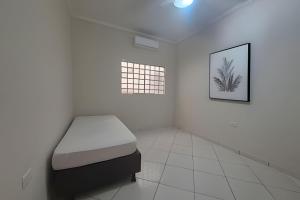 una stanza con un letto e un quadro sul muro di Refúgio Urbano Piscina, Churrasqueira e Conforto a Presidente Prudente