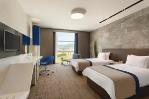 Postel nebo postele na pokoji v ubytování Ramada Hotel & Suites by Wyndham Izmir Kemalpasa