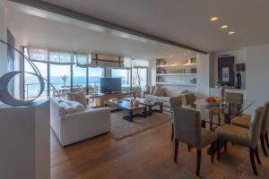 Una sala de estar con muebles blancos y vista al mar. en Extra Luxurious Apartment on the Beachfront., en Salinetas