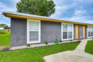 a gray house with white windows and a green yard at Mins to Beaches and HCA Hospital Fort Pierce Home in Fort Pierce
