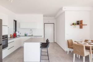 Una cocina con gabinetes blancos y una mesa y sillas. en O&O Group- Magical 4BR APT With Panoramic Sea View, en Bat Yam 33 fotos más