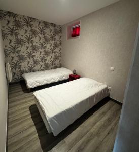 a bedroom with two beds and a red light at Le Gîte de la Vilaine in Sainte-Anne-sur-Vilaine
