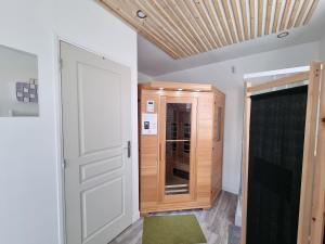 a room with a white door and a wooden closet at Évasion Relaxante 4 personnes Spa, sauna et calme 