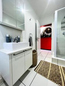 SandtonにあるLonehill Luxury Apartmentのキッチン(白いシンク、赤いドア付)
