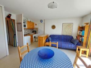 a living room with a table and a blue couch at Appartement cosy à Méaudre - 2 chambres, 5 pers, parking, lave-linge - FR-1-737-39 in Méaudre
