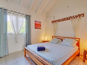 - une chambre avec un lit avec un cadre en bois et une fenêtre dans l'établissement Cocotier Charme, Confort & Détente près dOrient Bay - FR-1-734-78, à Cul de Sac 18 autres photos