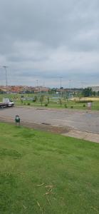 Un estacionamiento con un campo de césped y un camino. en Loft A Hospede-se em Frente ao Parque ecológico, en Indaiatuba
