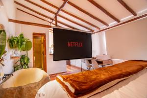 einen großen Bildschirm in einem Zimmer mit einem Bett in der Unterkunft Exclusiva cabaña con tina en piedra, fogata y cine in Villa de Leyva