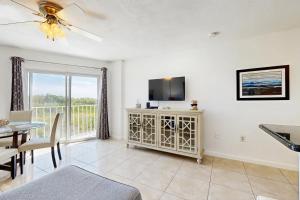 a living room with a flat screen tv and a table at Molliner Vacation Retreat in Tavernier