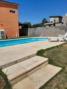 a swimming pool with a chair next to a house at La Orlinda in Potrero de Garay