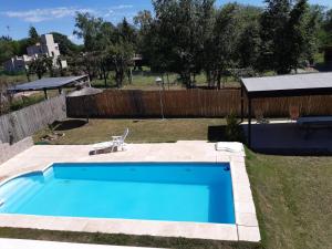 a blue swimming pool in a yard with a fence at La Orlinda in Potrero de Garay