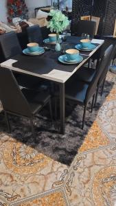 a dining room table with blue plates and chairs at Nassau Homestay in Opa-locka