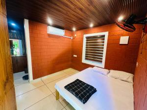 a room with a bed in a brick wall at Jungle Homes in Kollengode +13 photos