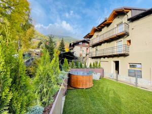 un cortile con vasca idromassaggio in erba di Mulini 22 - Chalet & spa apartments a Temù