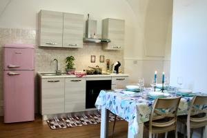 a kitchen with a table and a pink refrigerator at Ginetta House in Ordona +13 photos