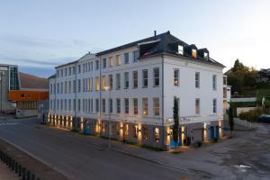 Un gran edificio blanco al costado de una calle. en Charming Retro-Modern Apartment in Centrum North, en Tromsø