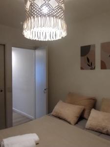 une chambre avec un lit et un lustre dans l'établissement Departamento en el Centro de Bariloche con Hermosa Vista solo con abono de SEÑA, à San Carlos de Bariloche 5 autres photos