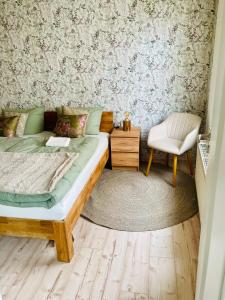 a bedroom with a bed and a chair at Ferienwohnung auf der Spreeinsel in Spremberg