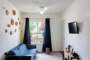 a living room with a blue couch and a window at Departamento-Rinconcito Uxmal in Playa del Carmen