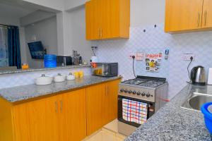 a kitchen with wooden cabinets and a stove top oven at GILGAL Homes in Kisii